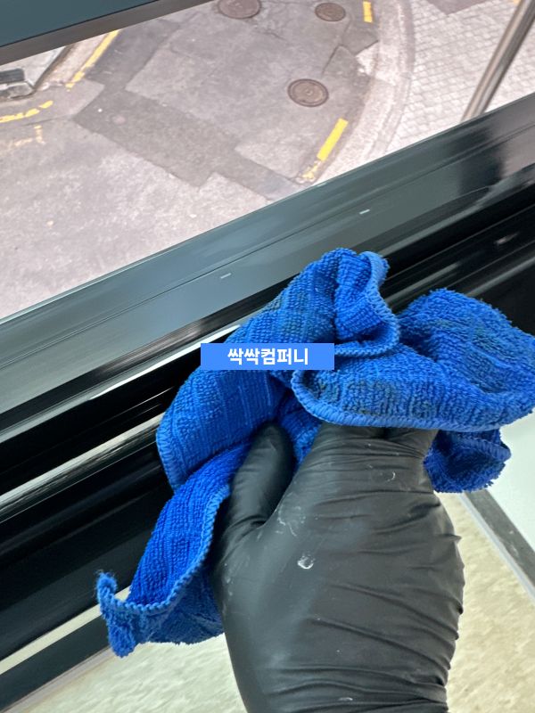 청소 전문가가 파란 장갑을 착용하고 표면을 닦는 모습 